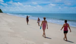 Four women walking along a quiet tropical beach in Panama, enjoying one of the best family-friendly vacation destinations.