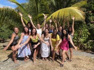 Smiling group of women at Istmo Retreat & Adventures in Panama for their wellness and yoga retreat under the palm trees — connection, joy, and empowerment in nature.