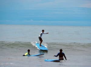 Kids learning to surf on the beach in Panama — part of the fun and family-friendly adventure activities offered by Istmo Retreat & Adventures.