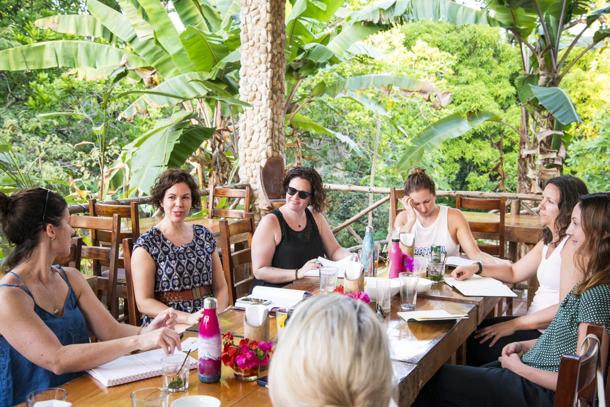 istmo-retreat-panama-wellness-yoga-retreat-LianneKim A group of women engaged in a workshop during Leanne Kim's wellness and yoga retreat on a jungle-view terrace at Istmo Retreat & Adventures in Panama — blending growth, creativity, and connection.