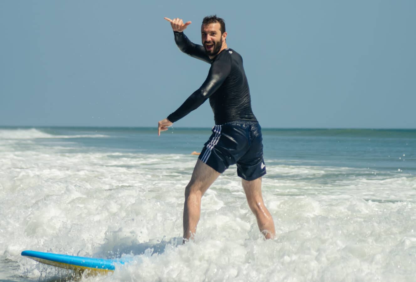 panama-surf-lesson-family-vacation-happy-man A joyful man learning to surf during a family vacation in Panama, showcasing one of the best family vacation destinations for adventure and fun.