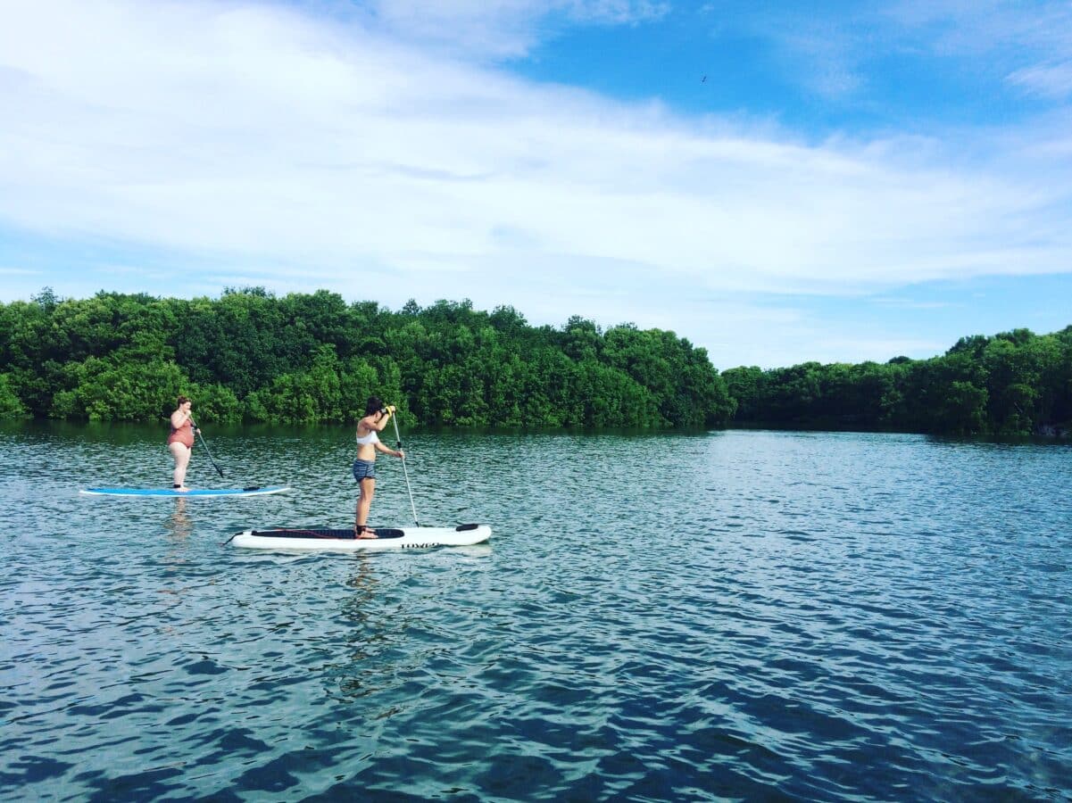 sup-lake-yoga-retreat-panama-Istmo-retreat Stand-up paddleboarding on a calm lake, a perfect activity for family adventure holidays.