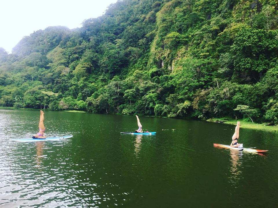 Group doing yoga on paddleboards in a serene lake during a yoga retreat in Panama. Group doing yoga on paddleboards in a serene lake during a yoga retreat in Panama.