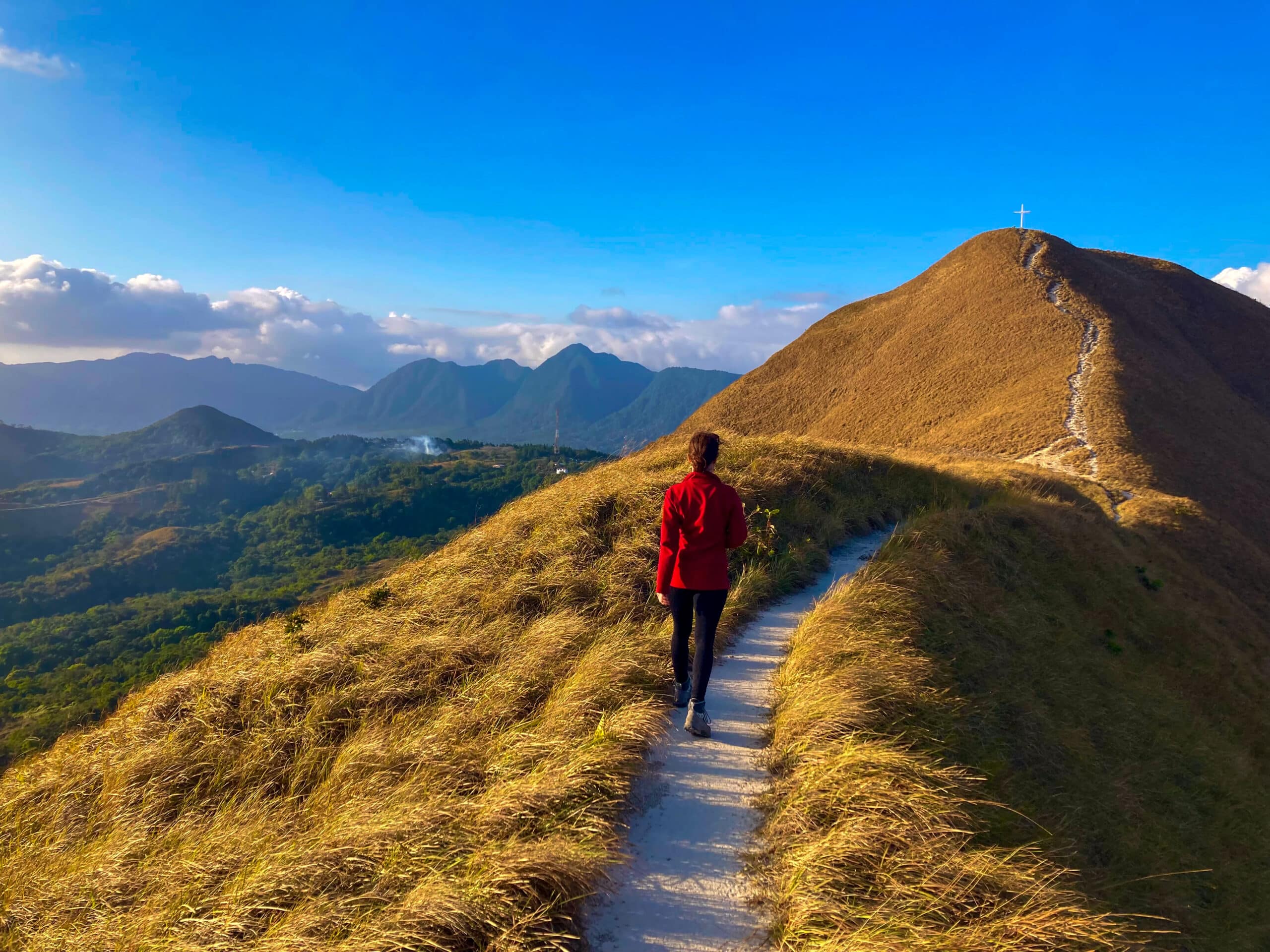 Young woman walking on narrow footpath in mountain area. Colourful mountain panorama. Traveling, active healthy lifestyle, hiking, adventure and exploration. Hills and mountains, Anton valley, Panama. Geology students examining volcanic caldera structure at El Valle de Antón Panama
